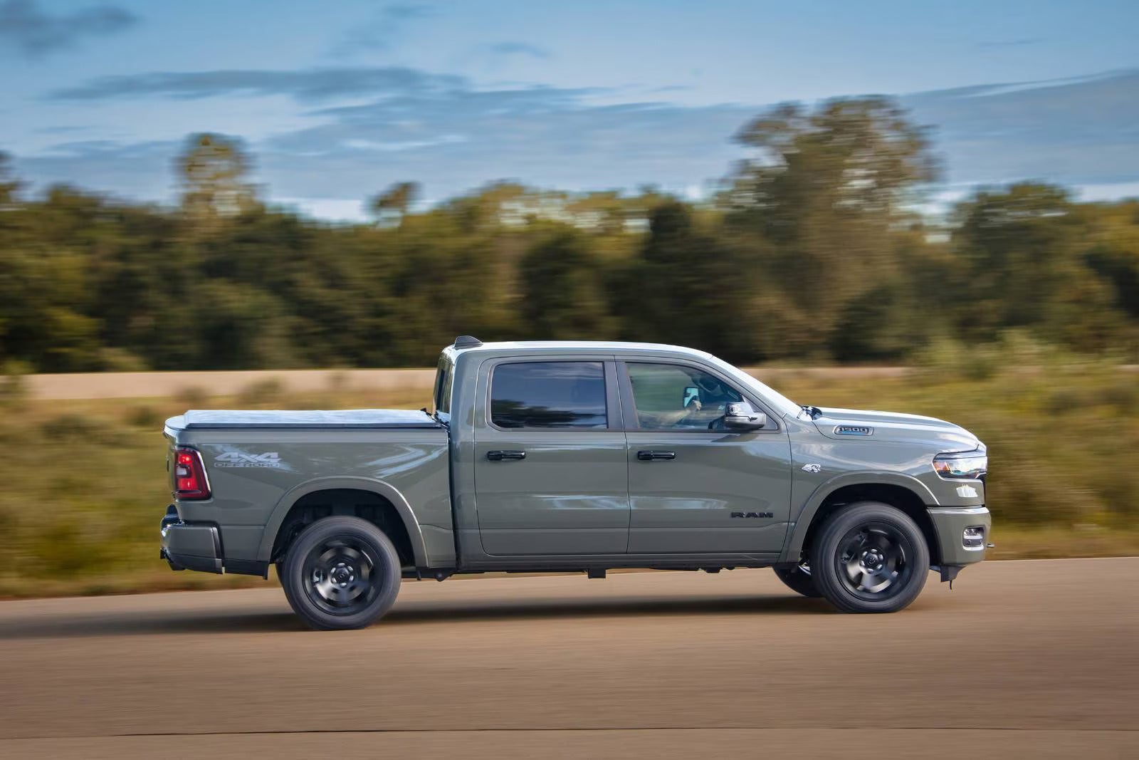 A green truck driving on the road.